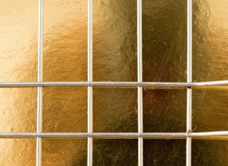 metal mesh on a gold backgroundの写真素材