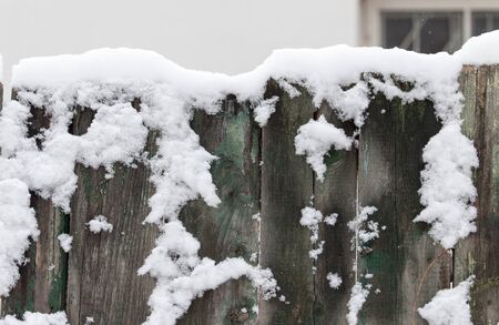 Snow on the wooden fence as a backdropの写真素材