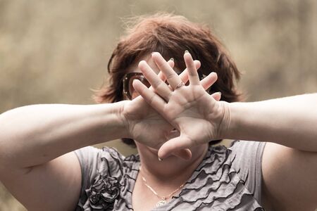 woman covers her face with her handsの写真素材