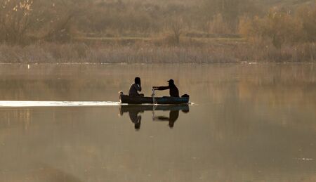 fishing boat on the lake at sunsetの写真素材