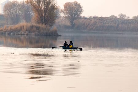fishing boat on the lake at sunsetの写真素材