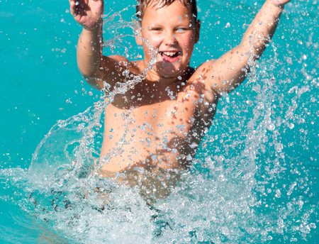 boy swims with a splash in the water parkの写真素材