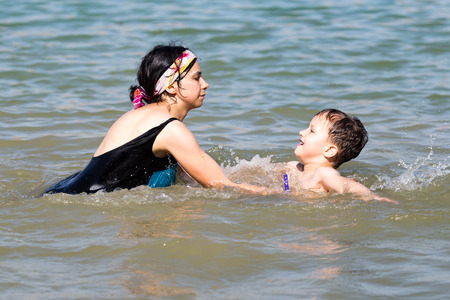 Mom and son swimming in the lakeの写真素材