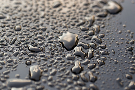 drops of water on a dark carの写真素材