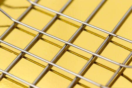 metal mesh on a gold backgroundの写真素材