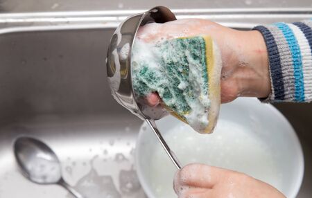 boy washing dishes in the kitchenの写真素材