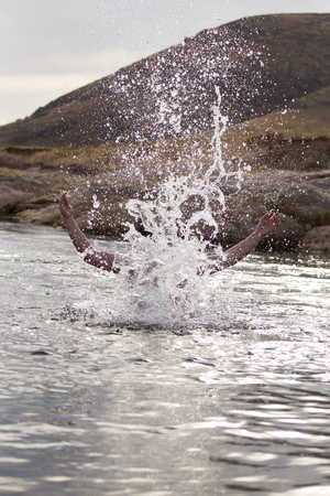 a man jumps out of the waterの写真素材