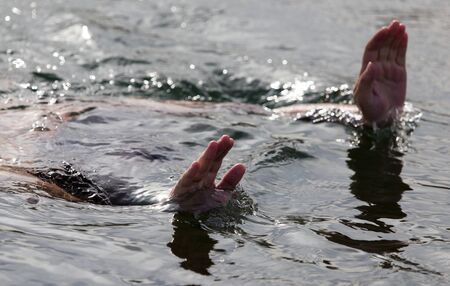 men's hands out of the waterの写真素材