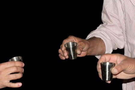 three wine glasses in hands on a black backgroundの写真素材