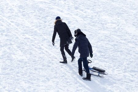 two guy riding the hills on sledsの写真素材
