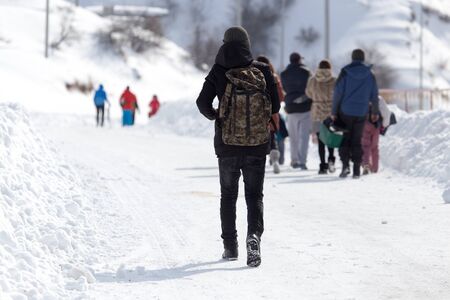 People families go for a snowy roadの写真素材