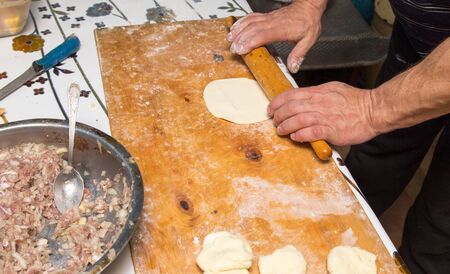 man prepares dumplings at homeの写真素材
