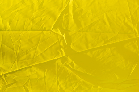 wrinkled yellow cloth as backgroundの写真素材