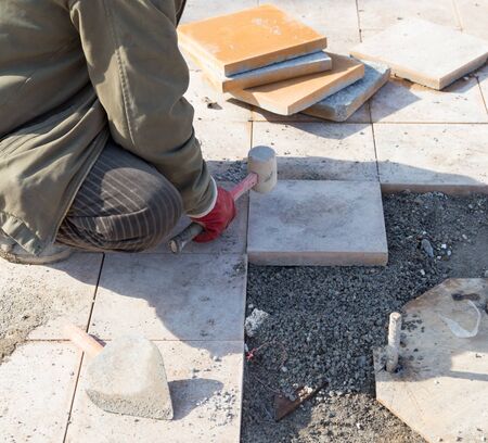 Worker puts sidewalk tileの写真素材