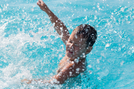 The boy is swimming in the poolの写真素材