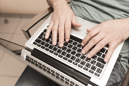 Hands of a man on a laptopの写真素材