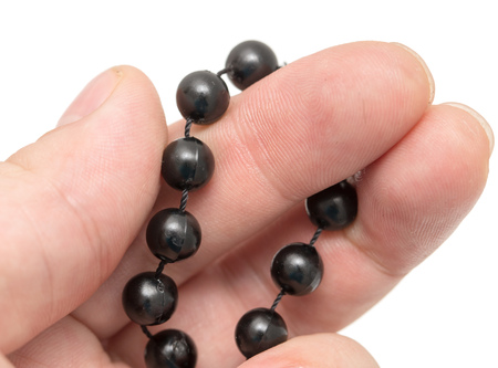 Black beads in hand on a white background