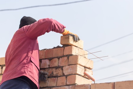 Worker builds a brick wall in the houseの写真素材