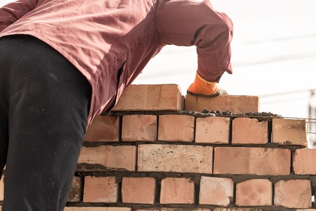 Worker builds a brick wall in the houseの写真素材