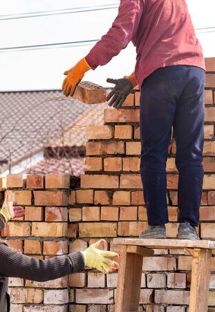 Worker builds a brick wall in the houseの写真素材