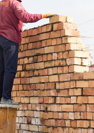 Worker builds a brick wall in the houseの写真素材