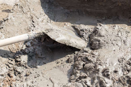 Worker kneads concrete at the construction site