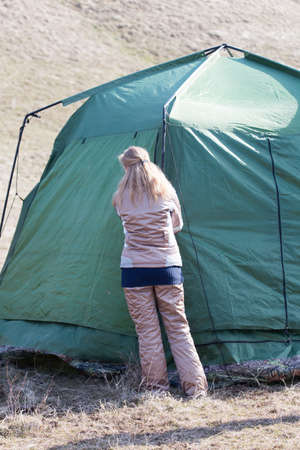Girl puts a tent on the natureの写真素材