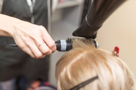 Styling female hair dryer in the beauty salonの写真素材