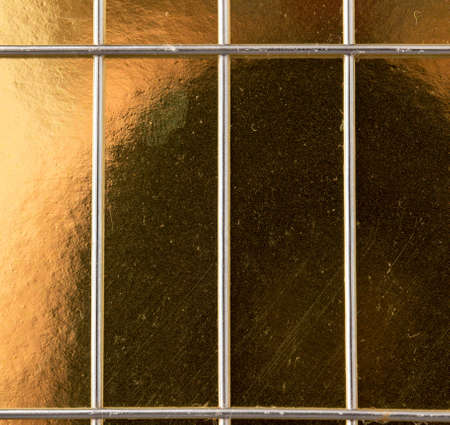 metal mesh on a gold backgroundの写真素材