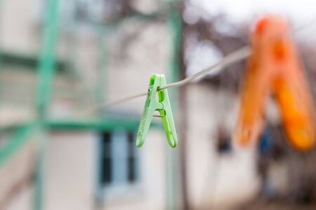A Colorful clothespins on the clothesline outdoors .