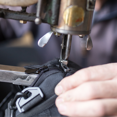 Tailor man sews up a bag in a workshop .の写真素材