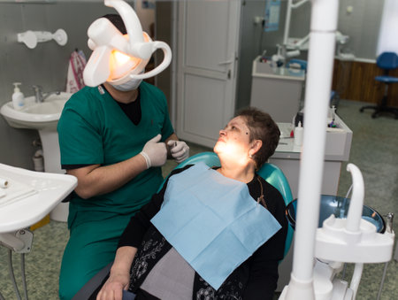 The dentist works with the client in the clinic .のeditorial素材