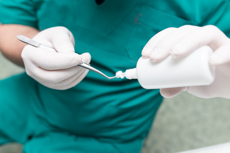 A dentist prepares an implant in the clinic .の写真素材