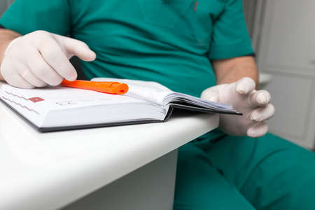 The doctor writes in a notebook at the clinic .の写真素材