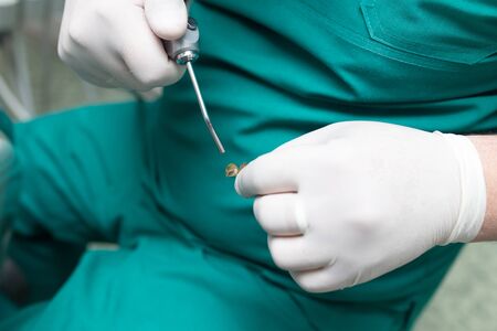 A dentist prepares an implant in the clinic .の写真素材