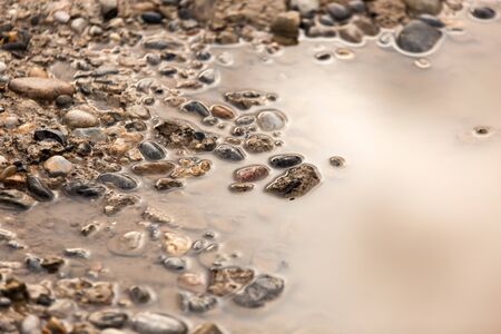 Puddle on the road with stones as background .の写真素材