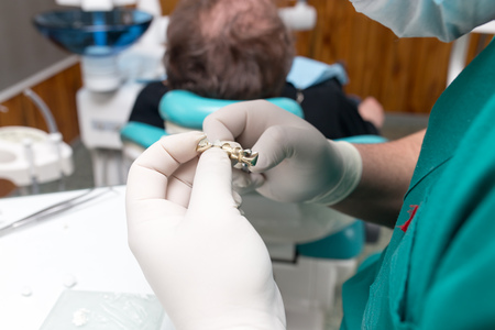 A dentist prepares an implant in the clinic .