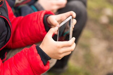 Boy playing computer games on a cell phone .の写真素材