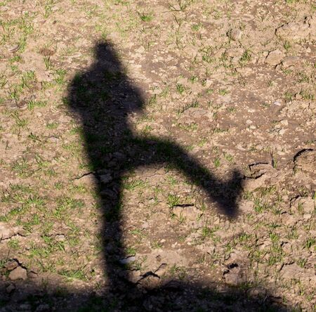 Man's shadow on the ground in natureの写真素材