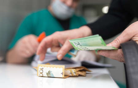 The doctor takes money from the patient .の写真素材