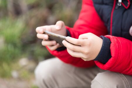 Boy playing computer games on a cell phone .の写真素材