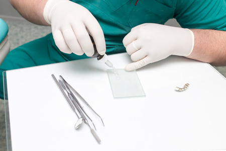 A dentist prepares an implant in the clinic .の写真素材