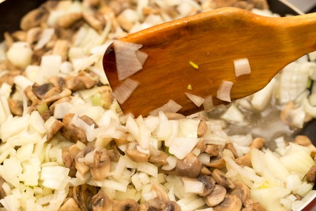 Mushrooms with onions are fried in a frying pan .の写真素材