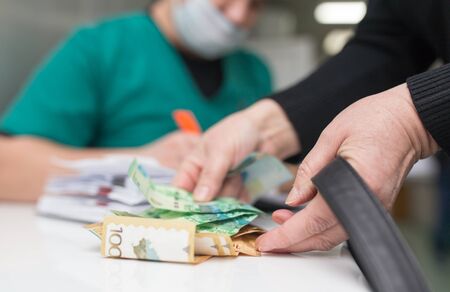 The doctor takes money from the patient .の写真素材