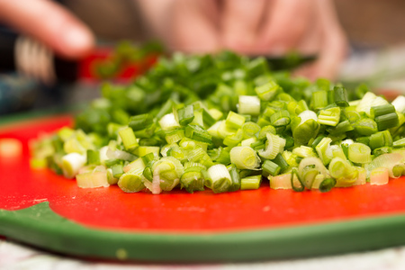 Cook cuts green onions with a knife .の写真素材