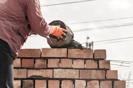 Worker builds a brick wall in the house .