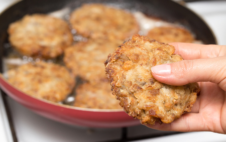 Fried chicken in a frying pan in hand .の写真素材