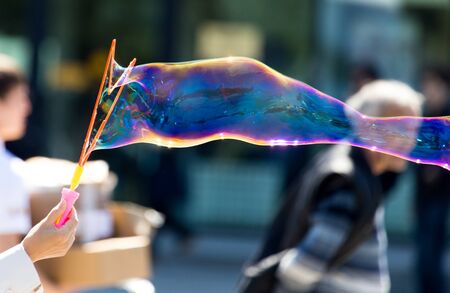 Beautiful soap bubbles fly in the city .
