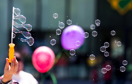 Beautiful soap bubbles fly in the city .