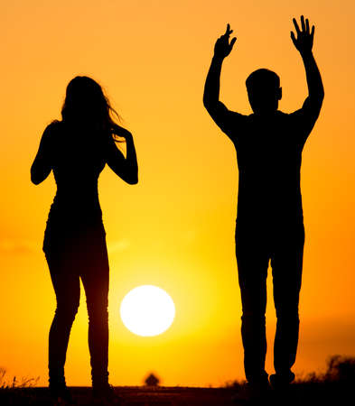 Silhouette of a guy and a girl at sunset .の写真素材